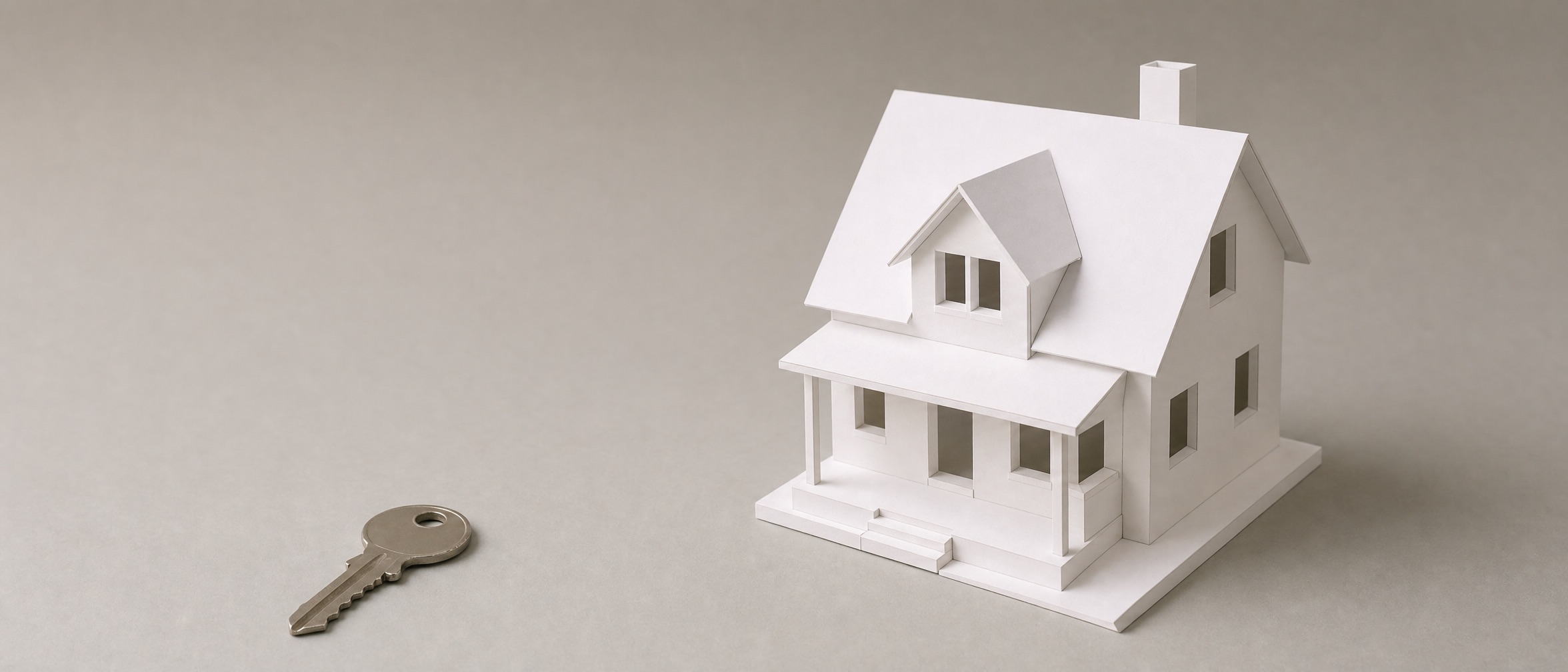 Weißes Architekturmodell eines Wohnhauses neben einem Schlüssel auf neutralem Grund (KI-Render)